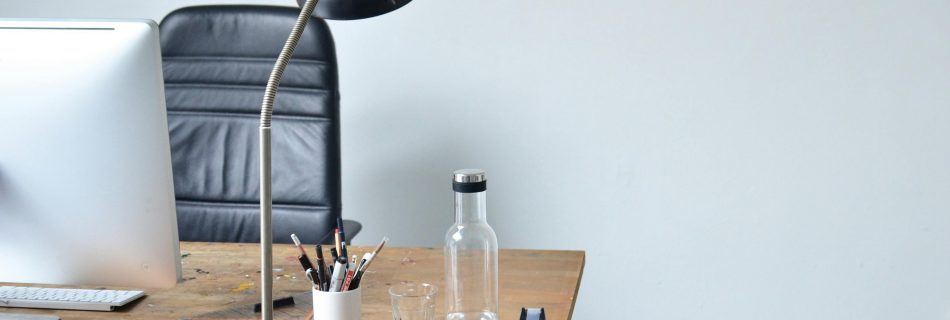 Heller minimalistischer Arbeitsplatz mit Laptop und strukturierter Arbeitsumgebung.
