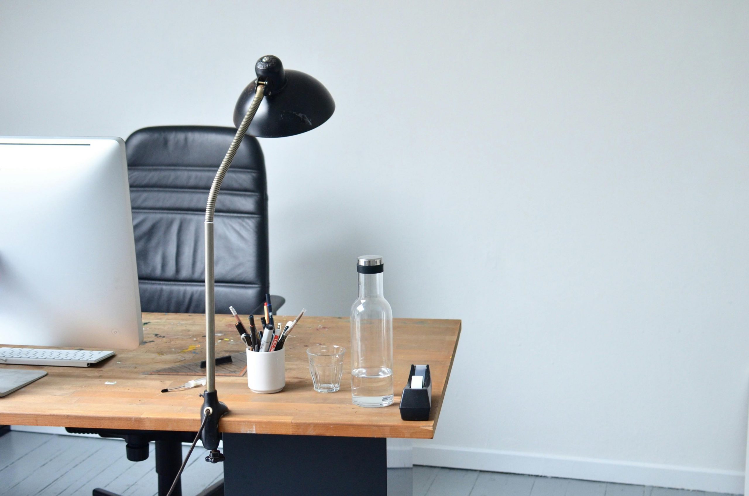 Heller minimalistischer Arbeitsplatz mit Laptop und strukturierter Arbeitsumgebung.